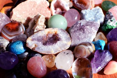 Güzel değerli taşlar, jeot ametist ve ahşap arka planda bulunan doğal mor mineral ametistleri. Ametist ve gül kuvars. Yarı değerli taşların büyük kristalleri..