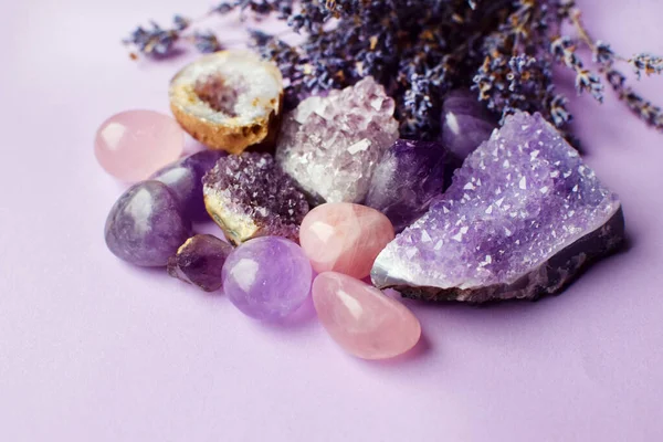 Beautiful amethyst crystals and round rose quartz stone with dry lavender bouquet. Magic amulets.