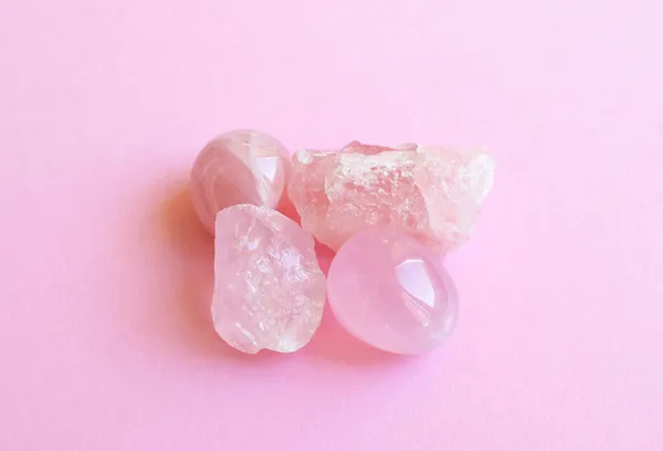 Crystals of rose quartz on a pink background. Beautiful semi-precious stones