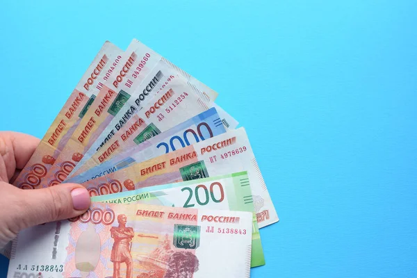Russische Roebel Bankbiljetten Een Vrouwelijke Hand Een Blauwe Achtergrond — Stockfoto