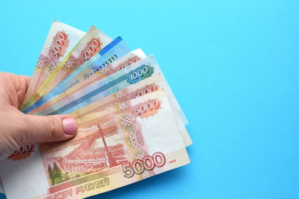 Russische Roebel Bankbiljetten Een Vrouwelijke Hand Een Blauwe Achtergrond — Stockfoto