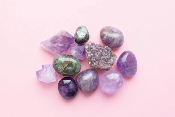 Gemstone minerals on a pink background. Round tumbling minerals of amethyst, rose quartz, apatite, turquoise, agate