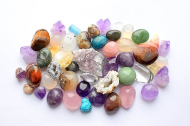 Farklı renkte mücevherler. Amethyst, rose quartz, agate, apatite, aventurine, olivine, turkuaz, aquamarine, sahte elmaslar beyaz arka planda bulunur. Üst yaşam