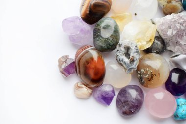 Farklı renkte mücevherler. Ametist, gül kuvars, agate, apatit beyaz arka planda yatar. Uzayı kopyala Üst yaşam