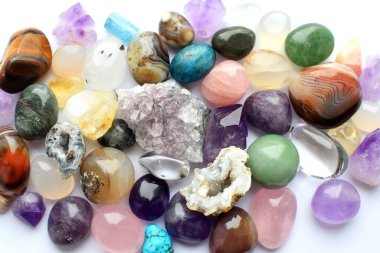 Farklı renkte mücevherler. Amethyst, rose quartz, agate, apatite, aventurine, olivine, turkuaz, aquamarine, sahte elmaslar beyaz arka planda bulunur. Üst yaşam