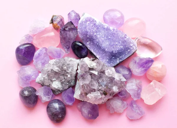 Druse and crystals of amethyst and rose quartz. Beautiful semi-precious stones lie on the table. Top view.