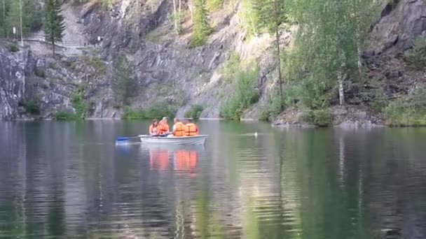 Ryssland, Leningradregionen 9 juli 2021: Rysslands landmärke, marmorstenbrottet Ruskeala reservat, Karelen. Turister i båt går in i en vattengrotta på en sjö i marmorkanjon i Ruskeala — Stockvideo