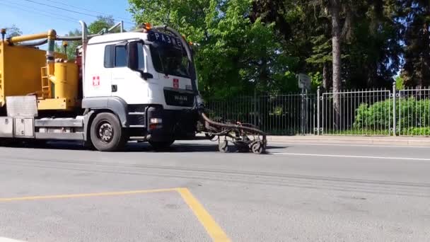 Rusland, Sint-Petersburg 31 mei 2021: Bij de voetgangersoversteek naar het asfaltoppervlak van een stadsstraat worden wegmarkeringen aangebracht voor speciale bouwvoertuigen — Stockvideo