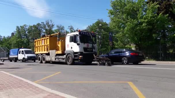 Росія, Санкт-Петербург 31 травня 2021 року: Спеціальний будівельний транспорт застосовує дорожні знаки на пішохідному переїзді до асфальтної поверхні вулиці міста. — стокове відео