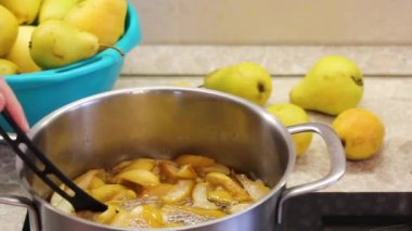 boiling fruit in syrup. making jam from yellow pears at home