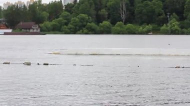 A man in a helmet rides a wakeboard in a wake park. jumping over obstacles on the water. active sports
