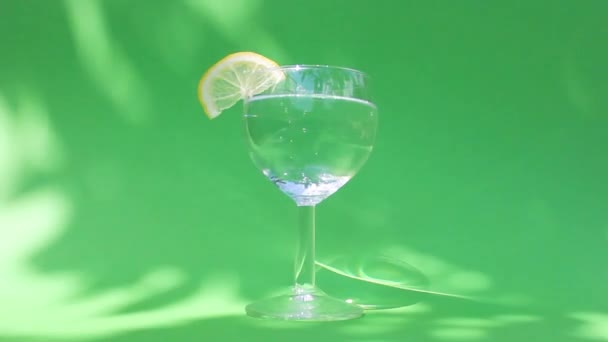 A woman hand takes a glass of refreshing cold water with a slice of lemon. the concept of making summer cocktails — Stock Video