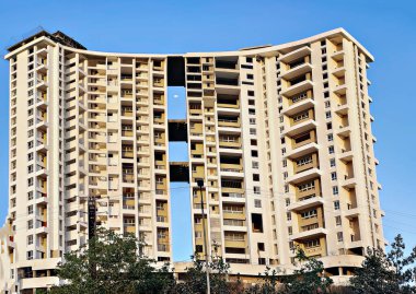 Mavi gökyüzünün arka planında yapım aşamasında olan yüksek bina.