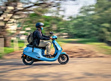 Pune, Maharashtra, Hindistan: - 7 Aralık 2021: Yavaş deklanşör, güvenlik için kask takan bir binicinin hareket bulanık görüntüsü,.