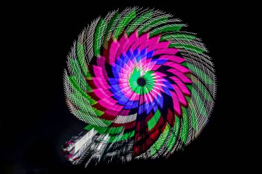 Kasıtlı kamera hareketi, yavaş deklanşör zoom bulanık dev dönme dolabın görüntüsü aydınlatılmış ve gece bir lunaparkta dönüyor.