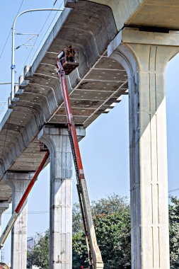 Pune, Maharashtra, Hindistan - 4 Ocak 2022: Pune metro raylarının bitirilmesi yüksek platform vinç işçileri tarafından yapılıyor.