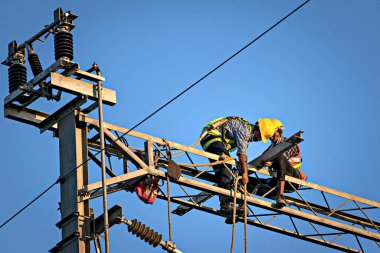 Pune, Maharashtra, Hindistan - 3 Şubat 2022: Pune Metro projesinin elektrik kablolarını tamir eden inşaat işçileri.