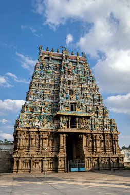 Hindistan, Madurai 'de mavi gökyüzü arka planına sahip antik Algar Koil Vishnu Kallazhagar tapınağının entrika oymalı renkli Gopuram' ı..