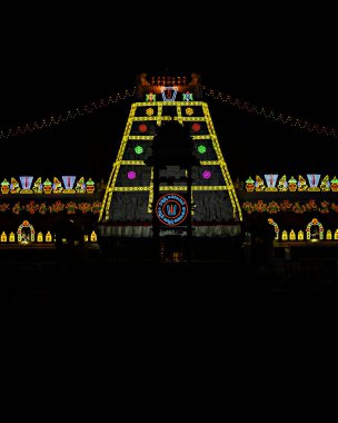 Andhra Pradesh, Hindistan 'daki ünlü Titupaty tapınağında gece aydınlatmasının dikey görüntüsü yapıldı. Metnin yerel Telugu dilinde tercümesi dini kaydet, seni kurtaracak demektir.