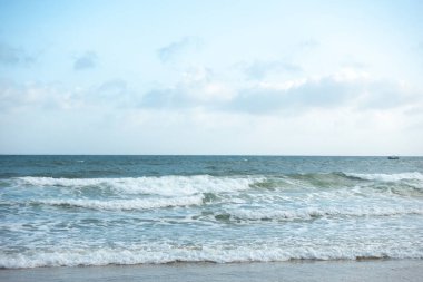 Mavi gökyüzünün altında deniz ve kum