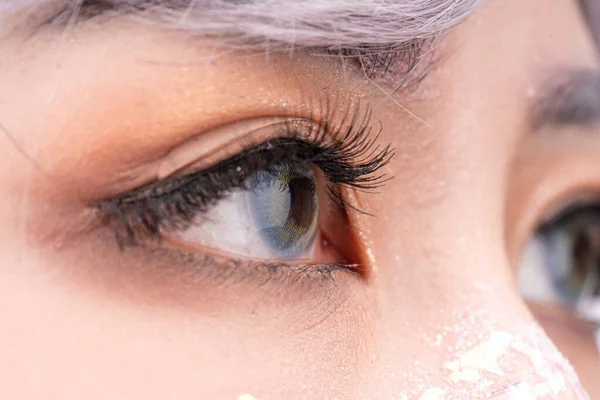 The pupil of an eye with colored contacts