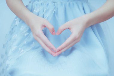 Mavi arka planda bir kızın elleri