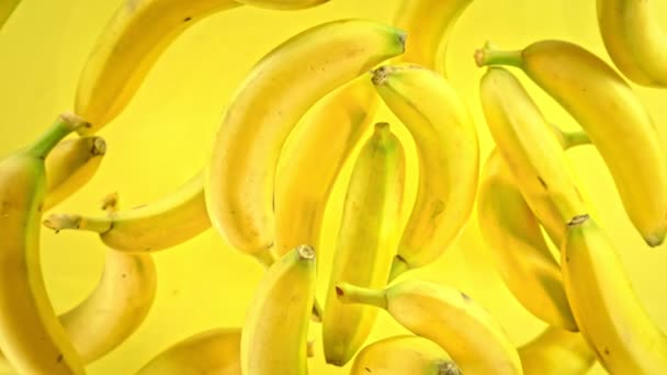 Супер Повільний Рух Свіжих Бананів Жовтому Тлі Літаючої Камери Швидкості — стокове відео