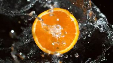 Dönen Portakal Dilimi ve Sıçrayan Su 'nun Süper Yavaş Çekimi. 4K 'da yüksek hızlı sinema kamerası ile çekildi...