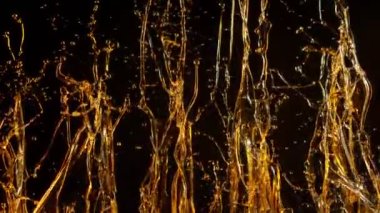 Kara Arkaplanda Altın Yağ Sıçratma 'nın Süper Yavaş Çekimi, 1000fps' te. 4K 'da yüksek hızlı sinema kamerası ile çekildi...