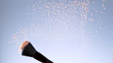 Süper Yavaş Hareketli Uçan ve Dönen Makyaj Fırçası ve Kahverengi Toz Çekimi. 4K 'da Yüksek Hız Sinema Kamerasında Çekim.