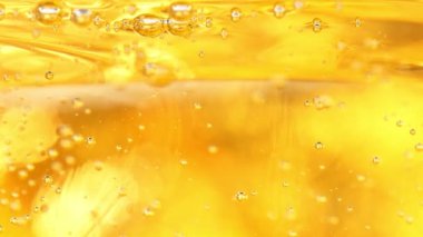 Yükselen Petrol Baloncuklarının Süper Yavaş Çekimi 600fps 'de Altın Arkaplan. Yüksek Hız Sinema Kamerası ile 4K çözünürlükte çekilmiştir.