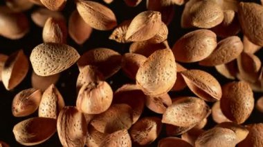 Süper Yavaş Çekim Kapanış Çekimi: Uçan Badem Cevizleri Siyah Kamera 'da 1000fps' te izole edildi. Yüksek Hız Sinema Kamerası ile 4K çözünürlükte çekilmiştir.