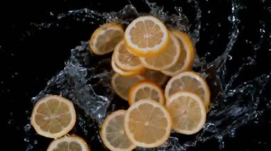 Süper yavaş çekim, patlamış limon dilimlerini, siyaha vuran suyla birlikte 180 metrede döndürmek. Yüksek hızlı sinema kamerasıyla çekilmiş..