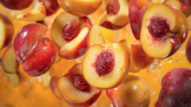 Şeftali Kesiklerinin Süper Yavaş Çekimi Turuncu Arkaplanda Kameraya doğru 1000 fps hızla uçuyor. 4K 'da Yüksek Hız Sinema Kamerası ile çekildi.