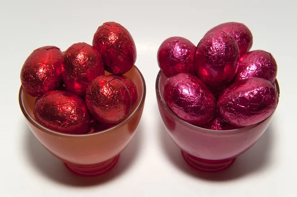 Colored chocolate Easter eggs in glass cups of the same color — Stock Photo, Image