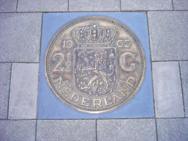 Coin of 2,5 guilders in pavement — Stock Photo, Image