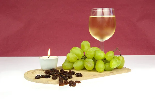 Raisins et raisins secs au vin blanc avec bougie — Photo