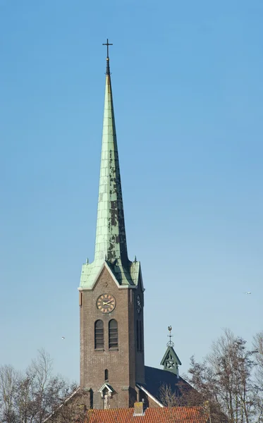 Hoge slanke kerk toren met kruis — Stockfoto