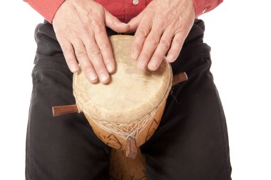 Man playing African drum on his lap clipart