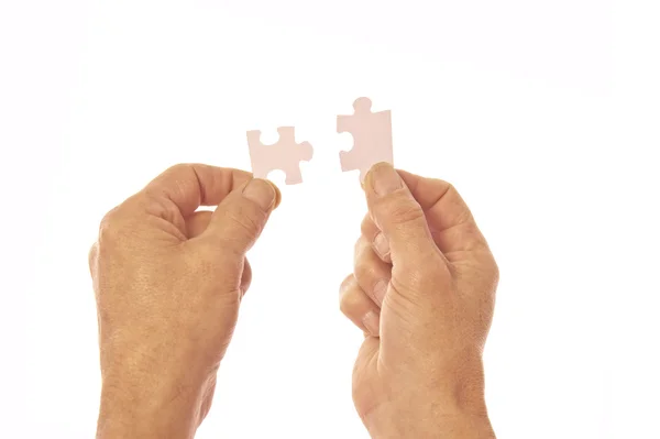 Duas mãos conectando peças de quebra-cabeça — Fotografia de Stock