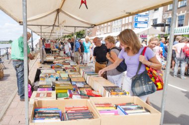 Market booth with second hand books and shopping people clipart