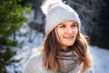 Beyaz, sarışın, gri süveter ve ponpon şapkalı mutlu kadının kış portresi..