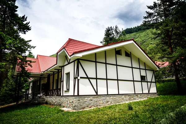 Corner view on one-storey private residential house with half-timbered decoration and stone base — Stock Photo, Image