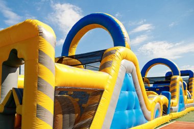Inflatable obstacle course slide for kid games or team building outdoor activities.