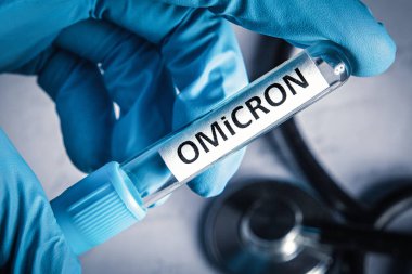 Doctor holding medical tube with sample of new variant of coronavirus mutations omicron. New covid 19 strain omicron, close-up.