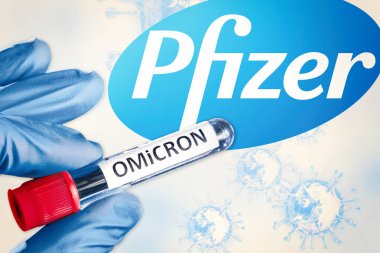 Almaty, Kazakistan - 14 Ocak 2022: Omicron varyant sars-cov 2 ile tıbbi tüpün yakın görüntüsü. Arka planda Pfizer logosu