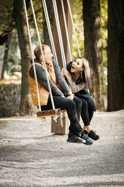 Вертикальное Изображение Счастливой Смеющейся Пары Сидящей Качелях Парке Открытом Воздухе — стоковое фото