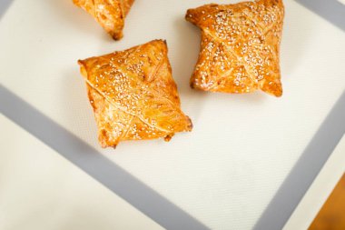 Mutfak masasında, üzerinde fotokopi alanı olan yeni pişmiş samosa hamur işi..