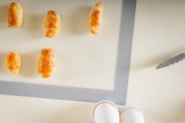 Taze pişmiş tatlı ev yapımı hamur işleri fırın paspası üzerinde simit, üst manzara ve uzay kopyası..