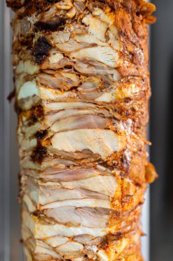 Türk sokak yemeği Doner Kebap için dikey şiş tavuk eti yakın çekim.